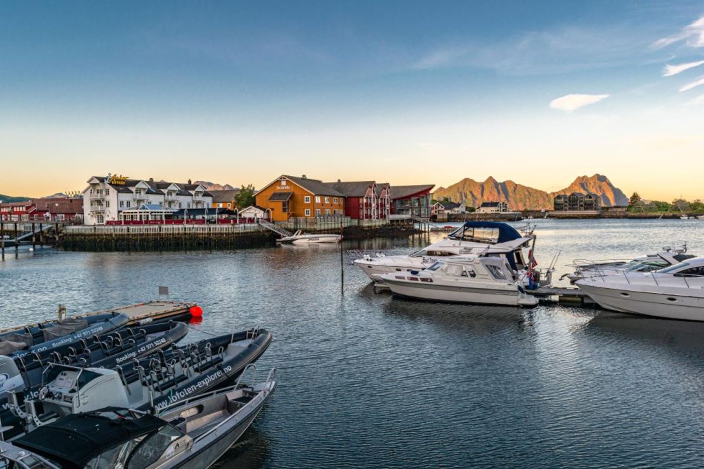 Hus, vatten och båtar med berg bakom sig i Svolvaer Lofoten