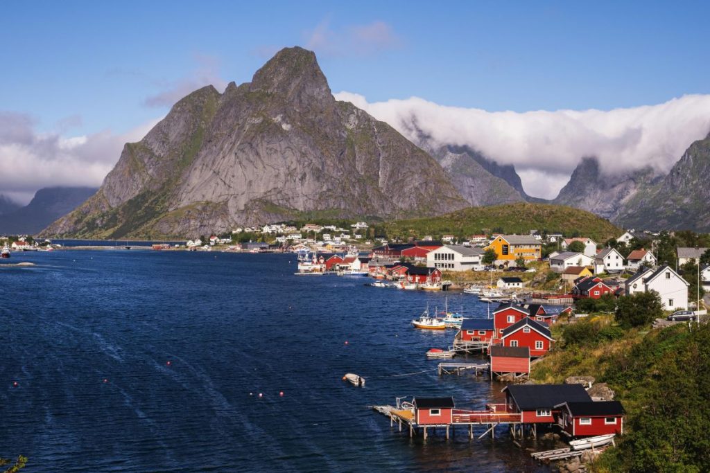 Små sjöbodar och hus framför ett berg i Reine, Lofoten